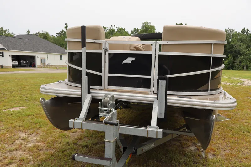 Slide: The Image of 2021 Starcraft LX 22 R pontoon boat on trailer, parked on grass. - 6