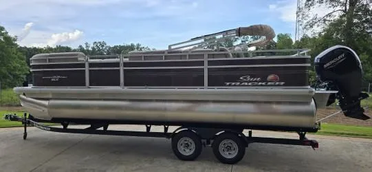 Slide: The Image of 2025 Sun Tracker SportFish 22 DLX pontoon boat on trailer, parked outdoors. - 3