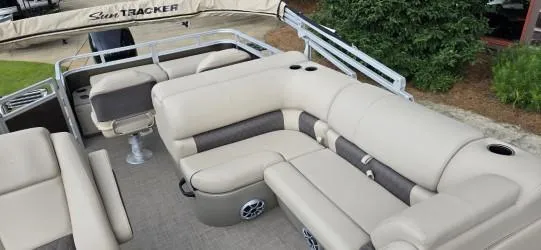 Slide: The Image of 2025 Sun Tracker SportFish 22 DLX pontoon boat with beige seating and cup holders. - 5