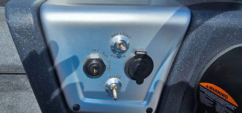 Slide: The Image of Control panel of 2025 Tracker Savage 215 boat with switches and ignition. - 11