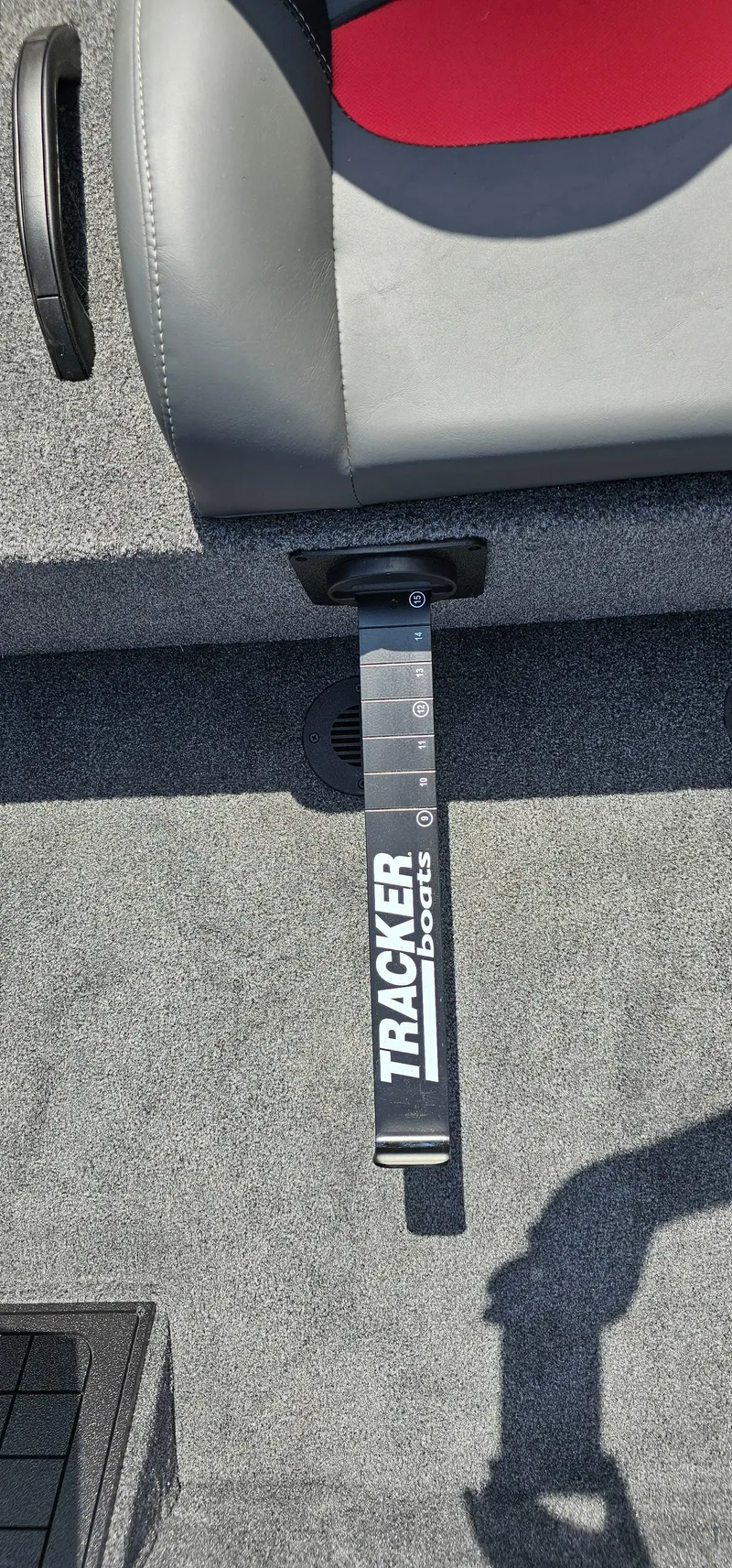 Slide: The Image of 2025 Tracker Savage 215 boat seat with branded footrest on carpeted floor. - 16