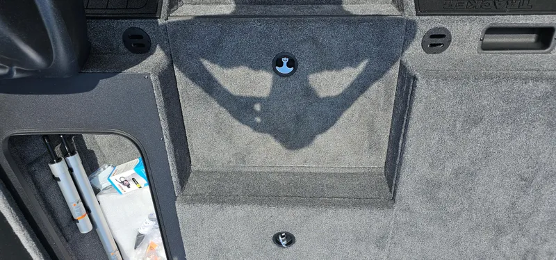 Slide: The Image of Interior of 2025 Tracker Savage 215 boat, featuring storage compartment and carpeted flooring. - 7