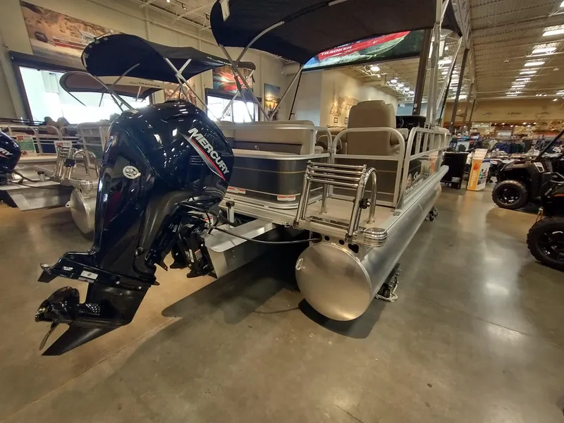 Slide: The Image of 2025 Sun Tracker Party Barge 18 DLX pontoon boat with Mercury outboard motor in showroom. - 15