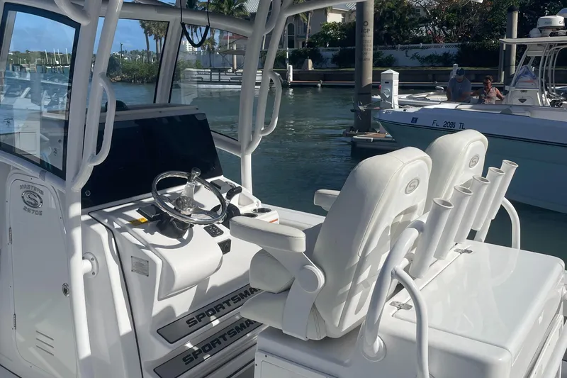 Slide: The Image of 2020 Sportsman Masters 267OE Bay Boat interior with helm and seating, docked in marina. - 6
