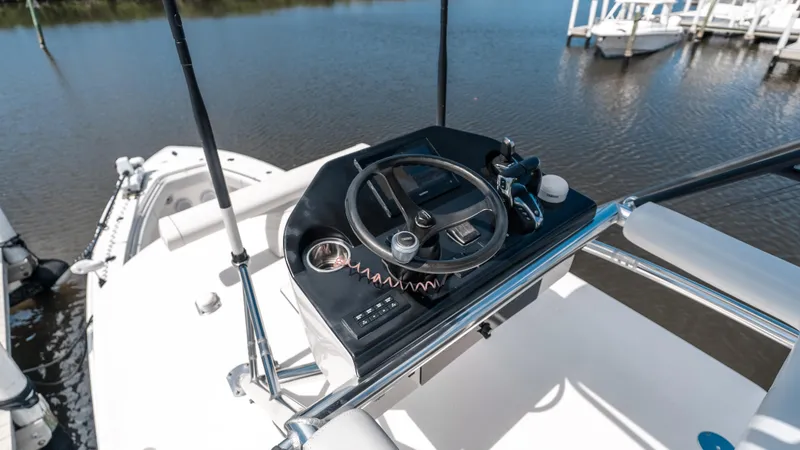 Slide: The Image of 2023 Contender 39 ST boat helm with steering wheel and controls on calm water. - 19