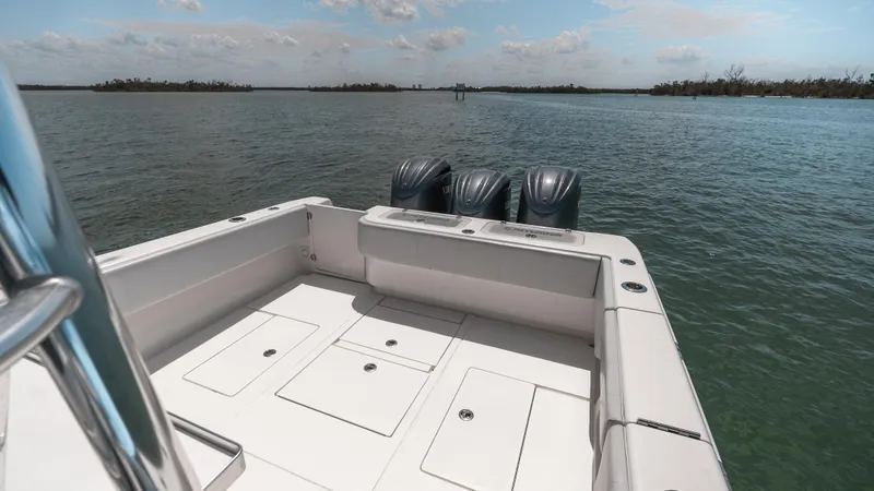 Slide: The Image of 2023 Contender 39 ST boat with triple engines on calm water. - 24