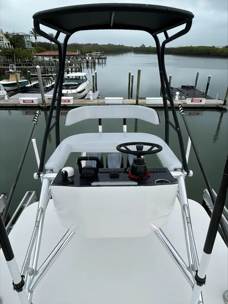 Slide: The Image of 2023 Contender 39 ST boat helm with controls, overlooking a marina. - 5