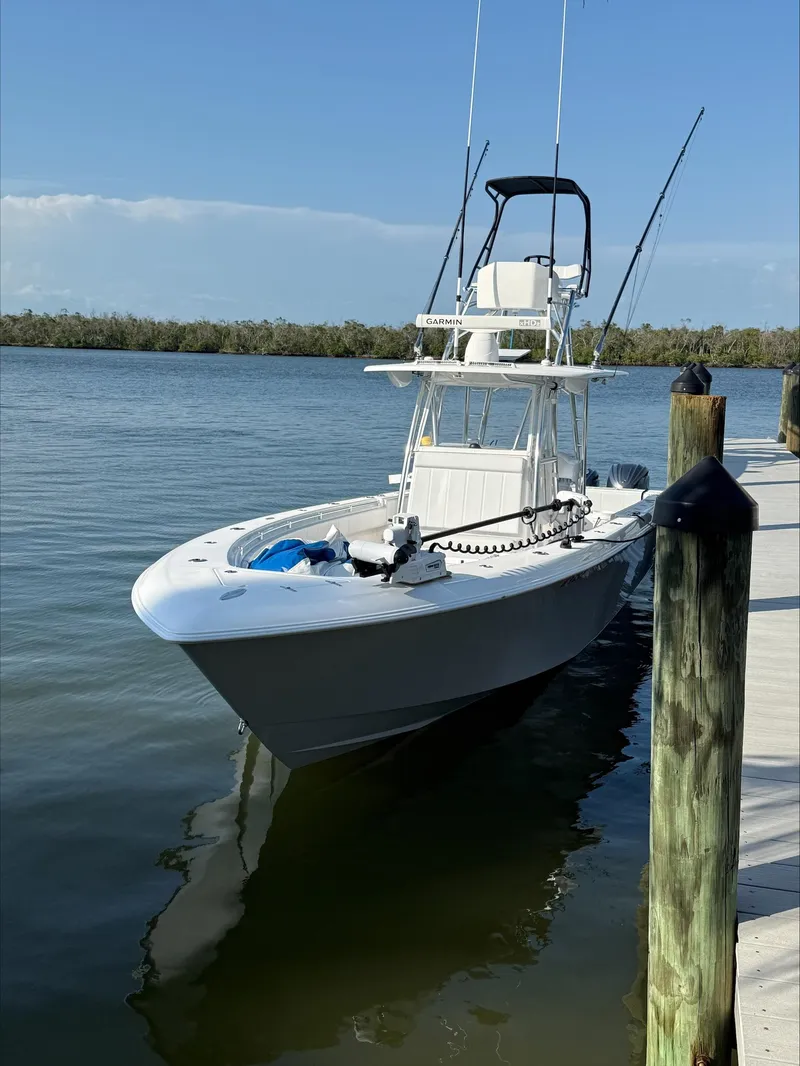 Slide: The Image of 2023 Contender 39 ST boat docked on calm water under clear blue sky. - 7
