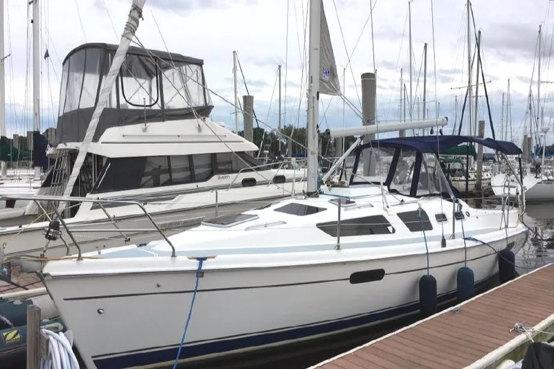 The Image of 2002 Hunter 326 sailboat docked at marina, featuring sleek design and white hull. - 0