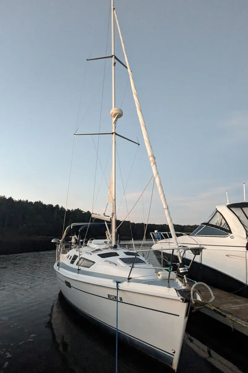 Slide: The Image of 2002 Hunter 326 sailboat docked at marina under clear sky. - 10