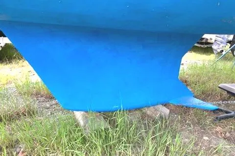 Slide: The Image of Blue keel of a 2002 Hunter 326 sailboat resting on grass. - 11