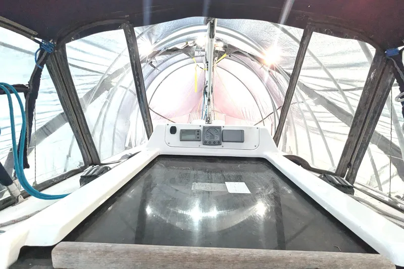 Slide: The Image of Cockpit view of a 2002 Hunter 326 sailboat under a protective cover. - 13