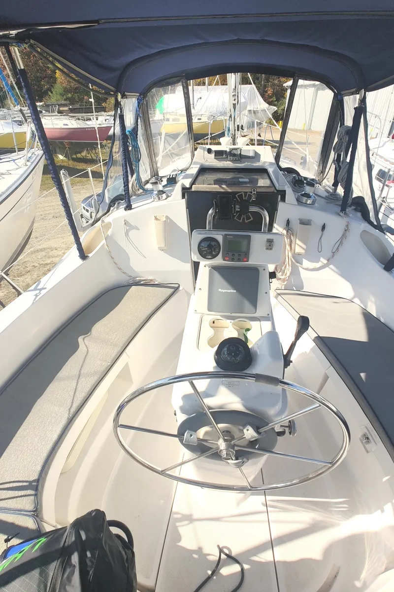 Slide: The Image of 2002 Hunter 326 sailboat cockpit with steering wheel and navigation instruments. - 14