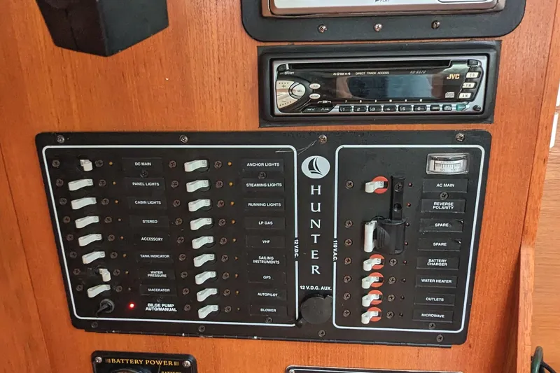 Slide: The Image of Electrical control panel on a 2002 Hunter 326 boat with switches and stereo system. - 18