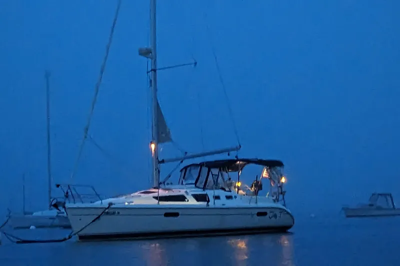 Slide: The Image of Sailboat Hunter 326, 2002 model, illuminated at dusk on calm waters. - 2