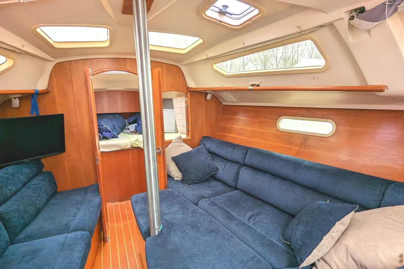 Slide: The Image of Interior of 2002 Hunter 326 sailboat with blue seating and wooden accents. - 21