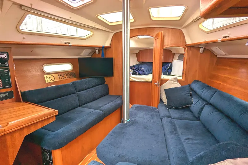 Slide: The Image of Interior of 2002 Hunter 326 sailboat with blue seating and wooden finishes. - 22