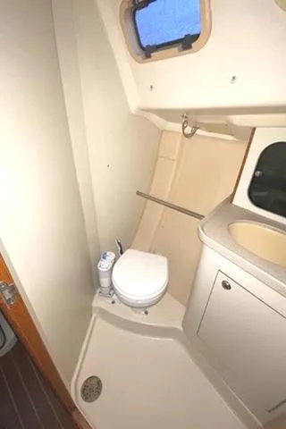 Slide: The Image of 2002 Hunter 326 boat bathroom with toilet, sink, and shower area. - 26