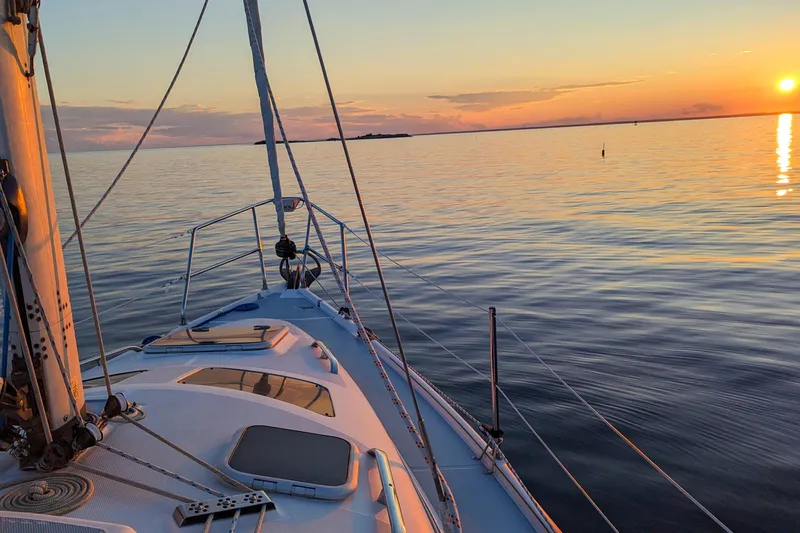 Slide: The Image of Sailing on a 2002 Hunter 326 yacht at sunset over calm waters. - 3