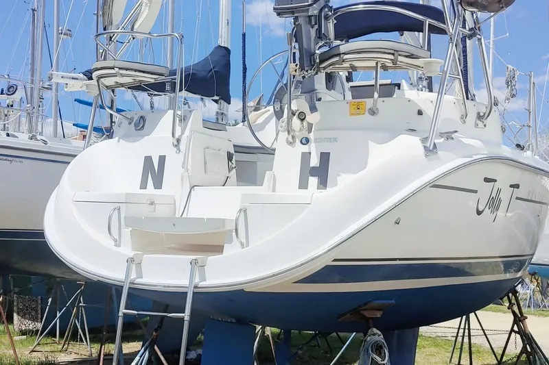 Slide: The Image of 2002 Hunter 326 sailboat on stands, featuring a white hull and blue accents. - 6