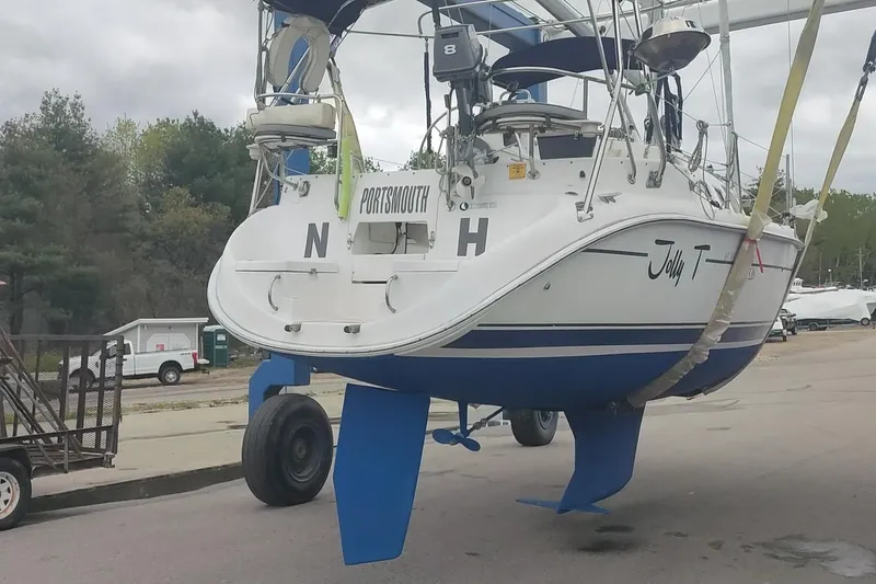 Slide: The Image of 2002 Hunter 326 sailboat on trailer, blue hull, named "Jolly T," in Portsmouth. - 8