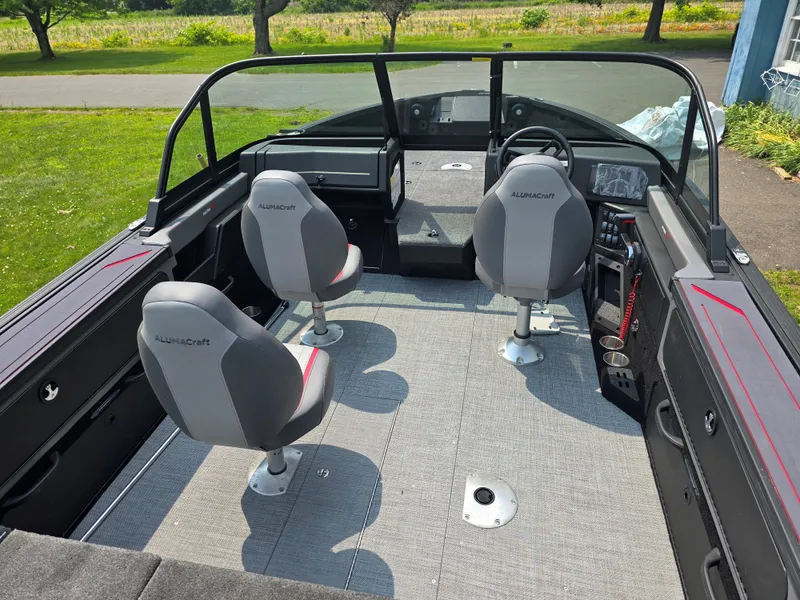 Slide: The Image of 2025 Alumacraft Trophy 185X SP FSX STD CV boat interior with three gray seats and modern dashboard. - 7