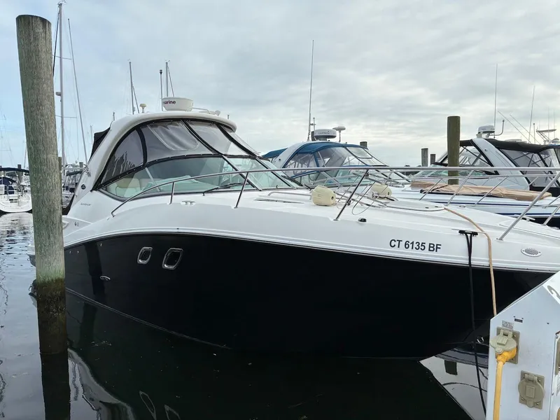 The Image of 2009 Sea Ray 330 Sundancer yacht docked at marina, overcast sky. - 0