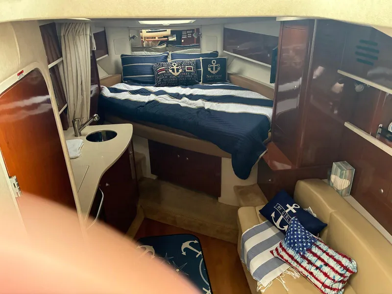 Slide: The Image of 2009 Sea Ray 330 Sundancer cabin with nautical-themed decor and cozy seating area. - 11