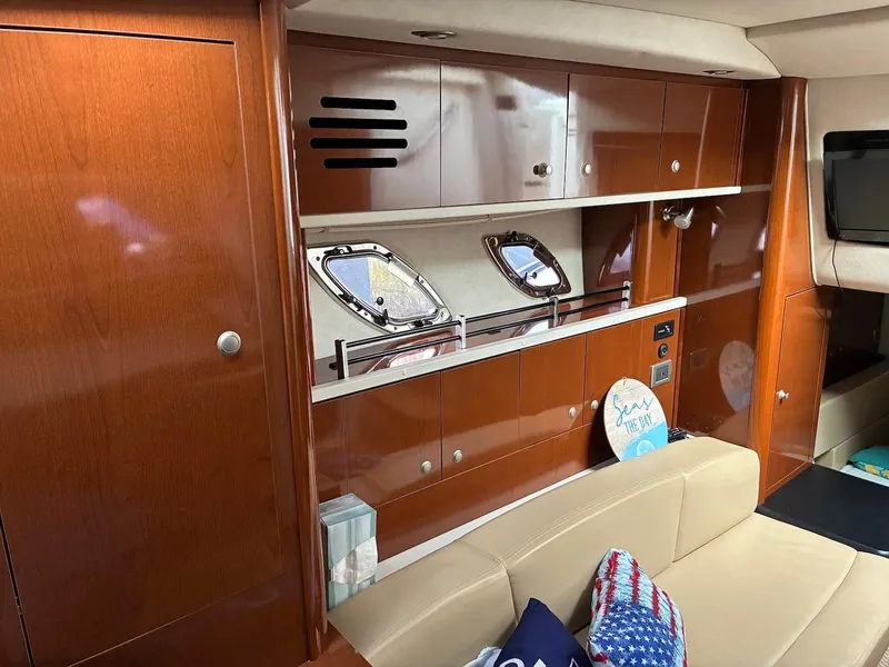 Slide: The Image of Interior of 2009 Sea Ray 330 Sundancer with wood cabinetry and beige seating. - 14