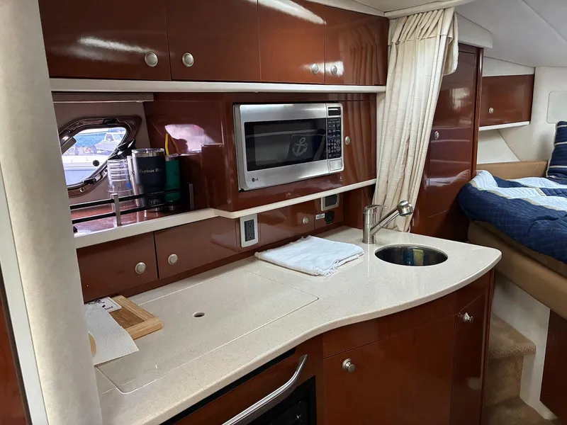 Slide: The Image of 2009 Sea Ray 330 Sundancer interior with kitchenette, microwave, and sink. - 16