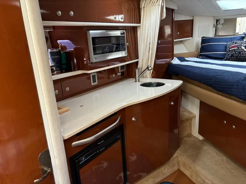 Slide: The Image of 2009 Sea Ray 330 Sundancer interior with kitchenette, microwave, sink, and cozy sleeping area. - 17