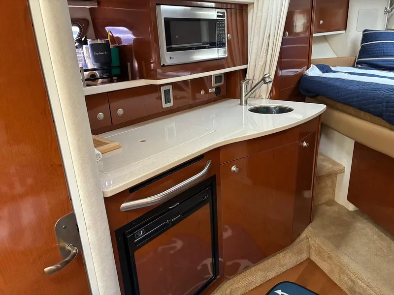 Slide: The Image of 2009 Sea Ray 330 Sundancer interior with kitchenette, microwave, and sink. - 18