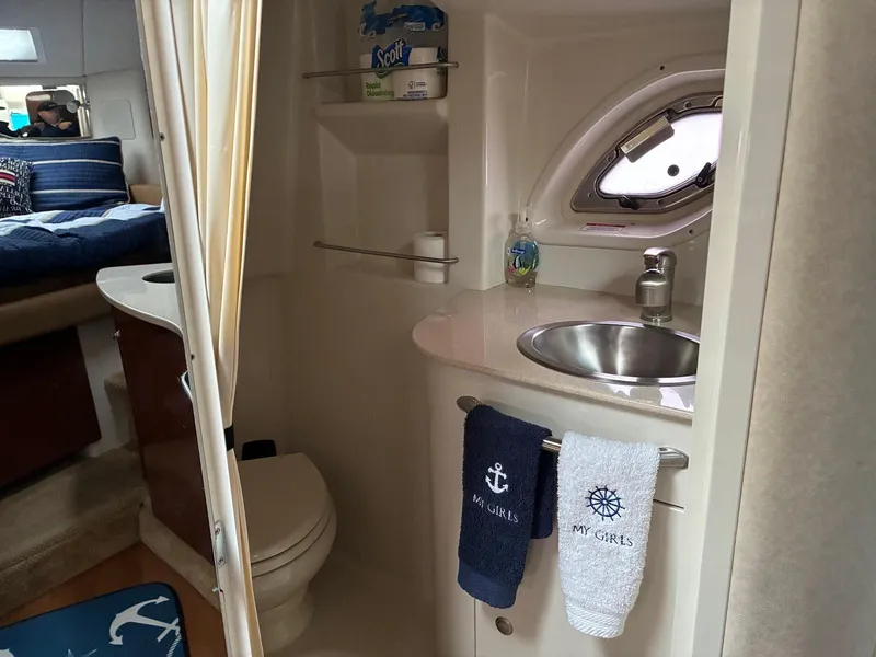 Slide: The Image of Interior of 2009 Sea Ray 330 Sundancer bathroom with sink, toilet, and nautical-themed towels. - 19