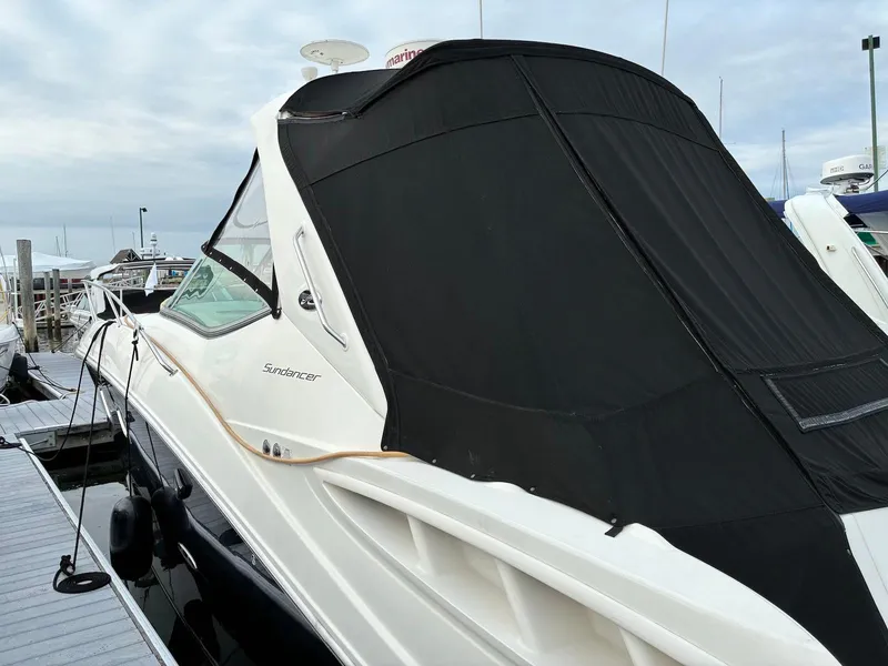 Slide: The Image of 2009 Sea Ray 330 Sundancer docked with black cover, side view. - 29