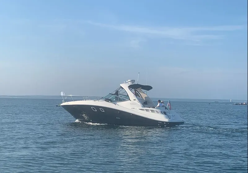 Slide: The Image of 2009 Sea Ray 330 Sundancer cruising on calm waters under a clear blue sky. - 3