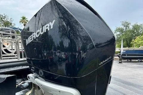 Slide: The Image of 2023 Regency 230 LE3 Sport with Mercury Verado outboard engine, parked outdoors. - 4