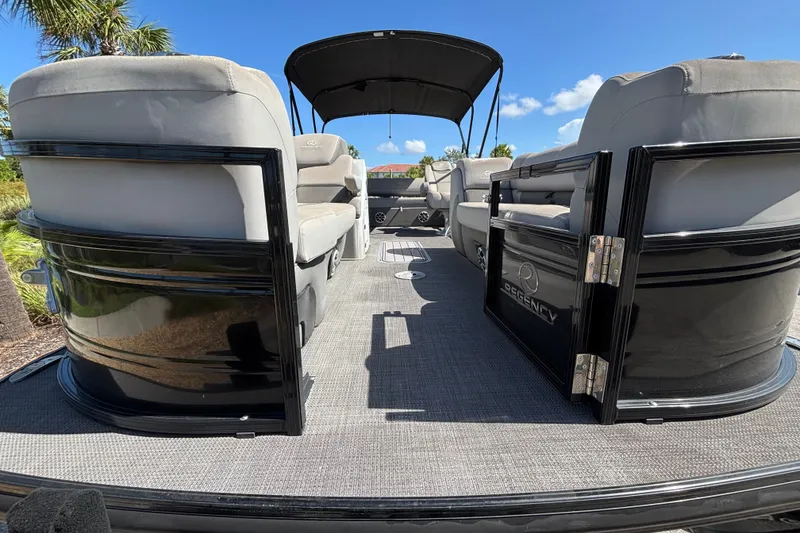 Slide: The Image of 2023 Regency 230 LE3 Sport pontoon boat with plush seating and canopy under blue sky. - 3