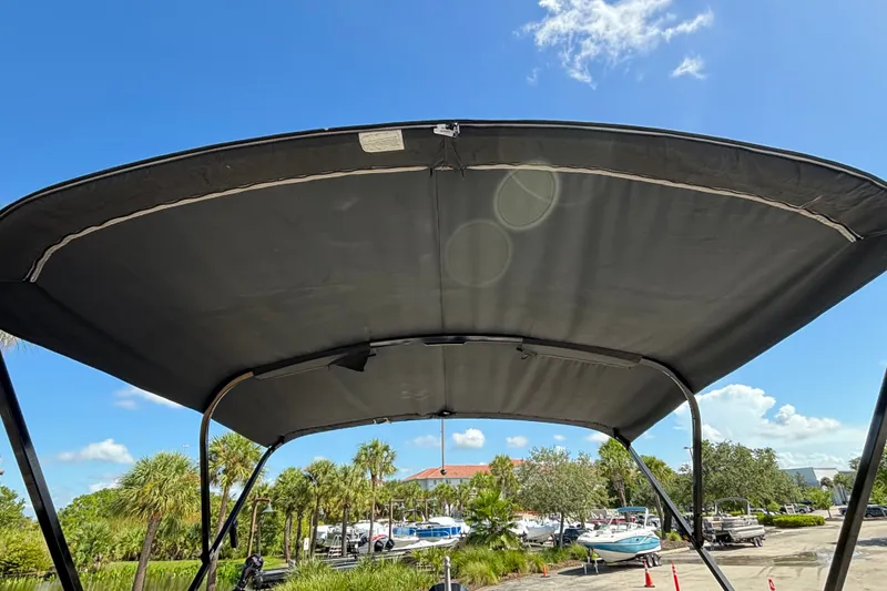 Slide: The Image of 2023 Regency 230 LE3 Sport boat canopy under clear blue sky. - 7