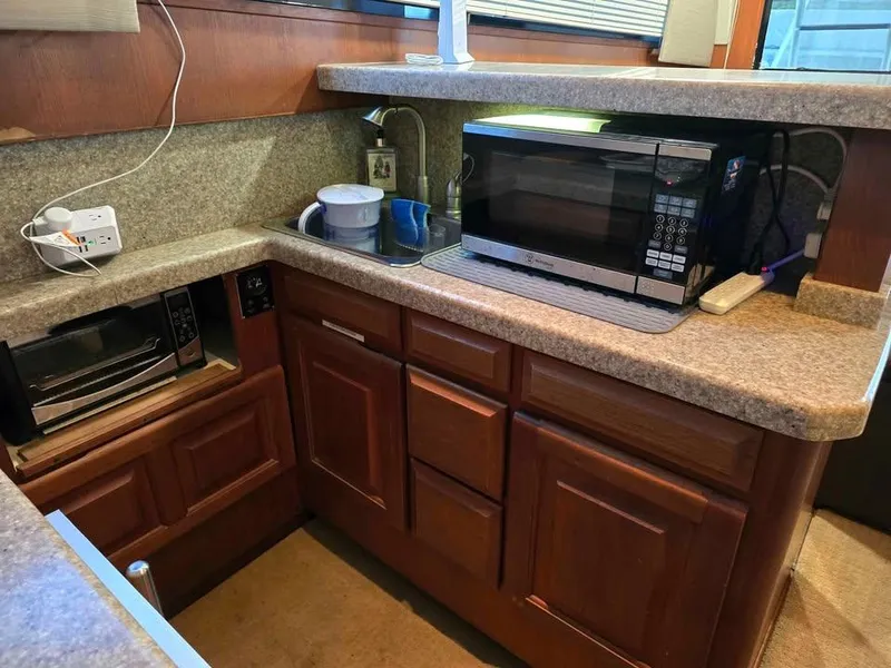Slide: The Image of Compact kitchen area in a 1990 Viking 35 boat with microwave and toaster oven. - 101