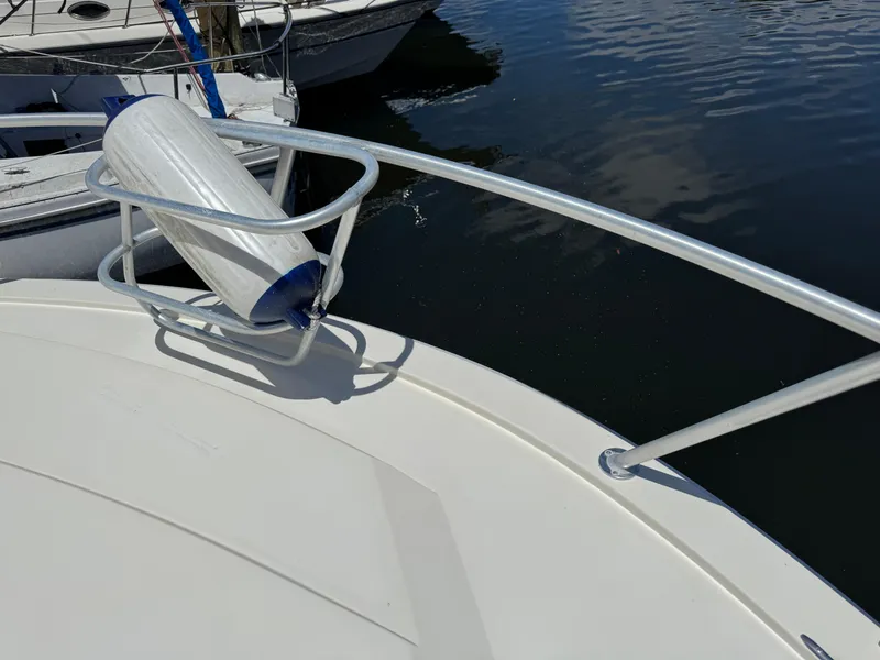 Slide: The Image of Bow of a 1990 Viking 35 boat with a fender, docked on calm water. - 12