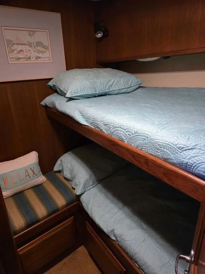 Slide: The Image of Bunk beds in a 1990 Viking 35 boat cabin with blue bedding and a "Relax" pillow. - 123