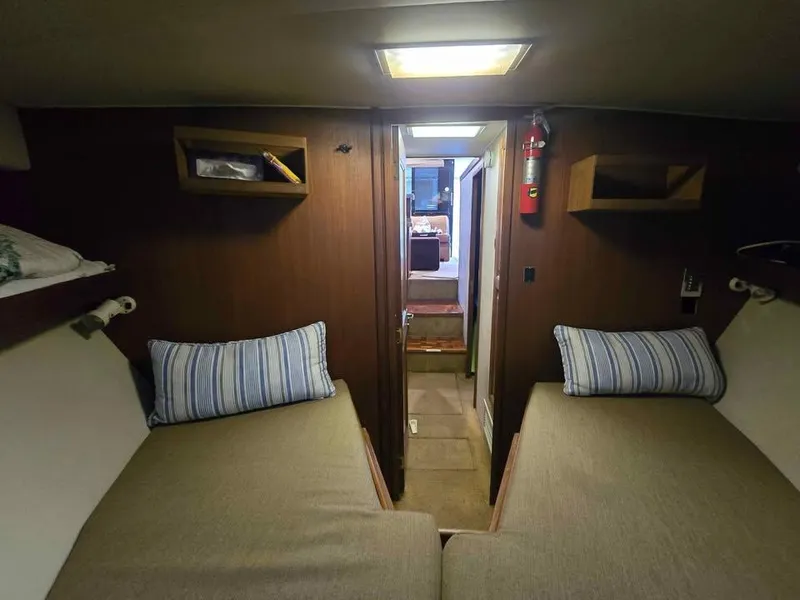 Slide: The Image of Interior of 1990 Viking 35 boat with twin beds and wooden paneling. - 125
