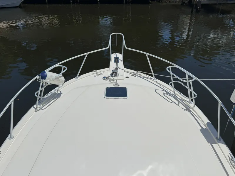 Slide: The Image of Bow view of a 1990 Viking 35 boat docked on calm water. - 14