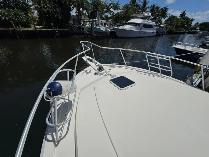 Slide: The Image of Bow of a 1990 Viking 35 yacht docked near palm trees and other boats. - 15