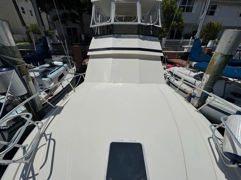 Slide: The Image of 1990 Viking 35 boat docked, showcasing spacious deck and cabin area. - 17