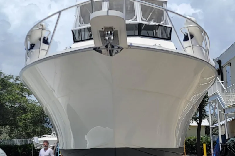 Slide: The Image of 1990 Viking 35 boat with sleek white hull, docked outdoors under a cloudy sky. - 2