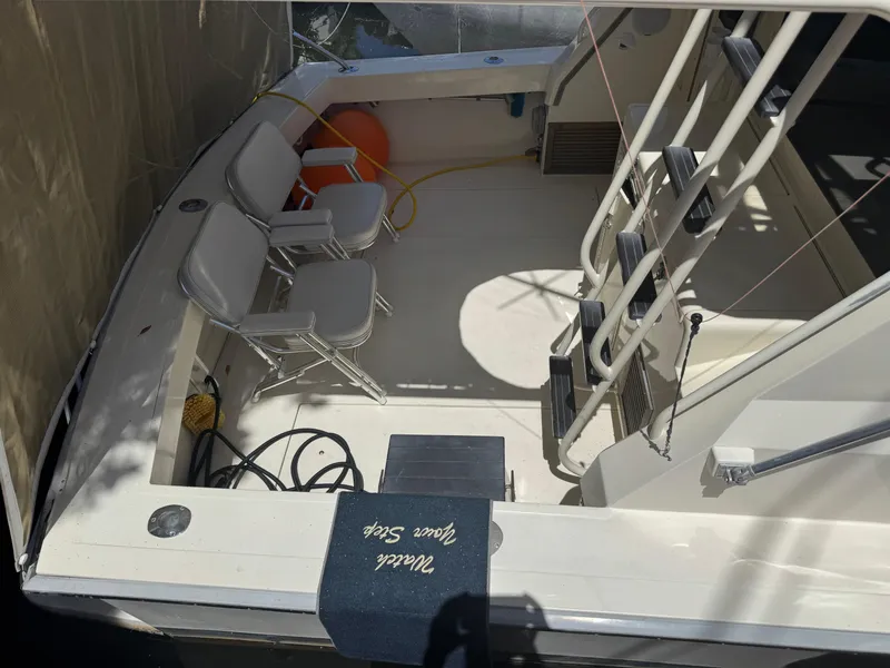 Slide: The Image of 1990 Viking 35 boat deck with chairs and ladder in sunlight. - 28
