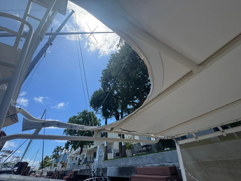 Slide: The Image of 1990 Viking 35 boat docked under clear blue sky with trees and houses nearby. - 35