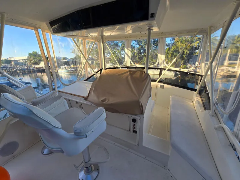 Slide: The Image of 1990 Viking 35 boat interior with helm, white seating, and clear windows. - 36