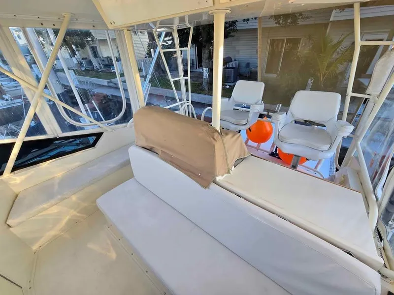 Slide: The Image of Interior of a 1990 Viking 35 boat with white seating and large windows. - 37